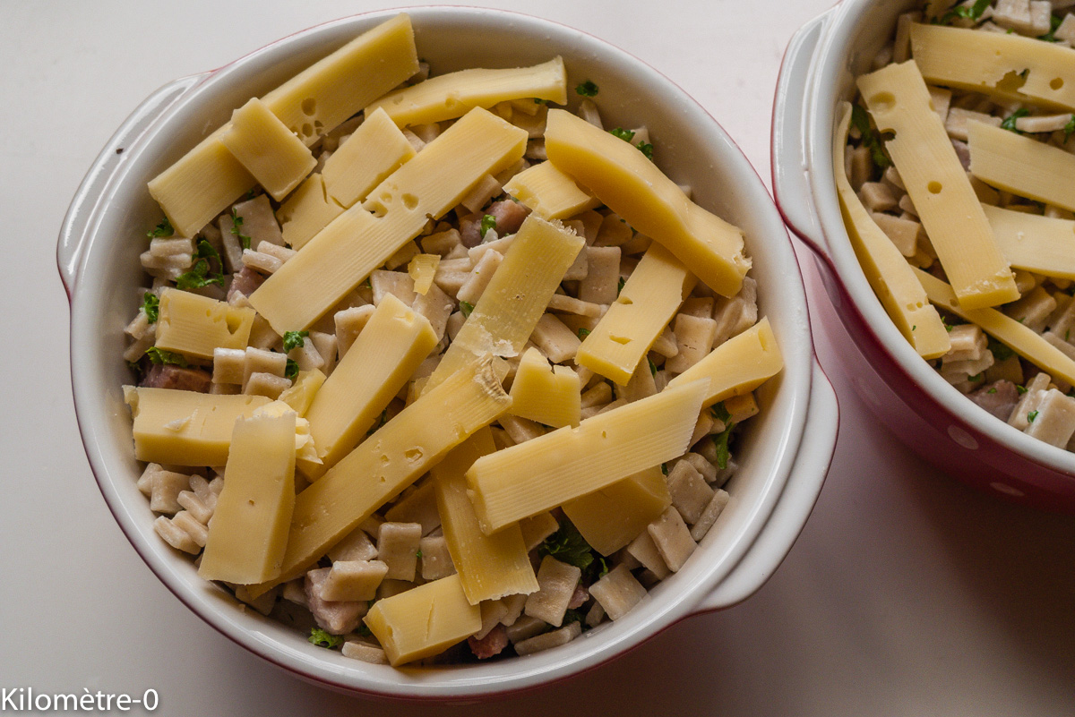 Gratin de crozets : étape 3 — Mettez-les dans des plats à gratin, parsemez de tranches de tomme et enfournez 10/15 m au four…