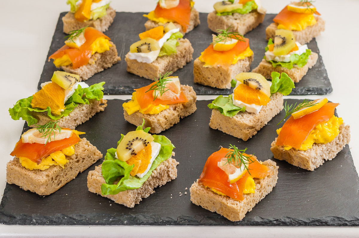 Photo de recette de Smorrebrod terre et mer (recette norvégienne) canapés, saumon fumé, truite fumée, fromage, fruits, pain, apéro facile, pain maison, rapide, healthy de Kilomètre-0, blog de cuisine réalisée à partir de produits de saison et issus de circuits courts